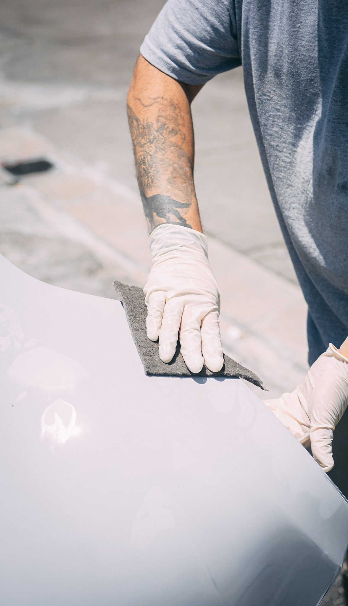One Stop Collision technician preparing a vehicle body panel for refinishing